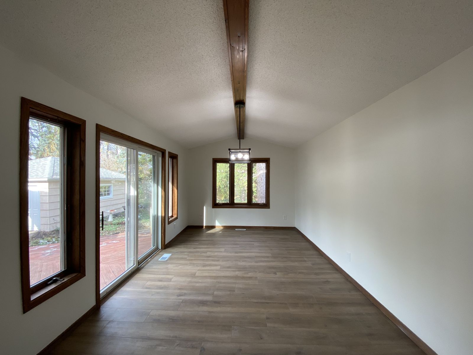 Bright back room with new flooring and sliding doors to the yard